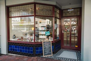 The exteriror of The Chocolate Story Petone with a blackboard sign outside.