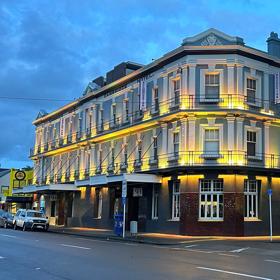 The Cambridge Hotel in Wellington. The hotel is housed inside a low-rise, corner-site public house building designed in the inter-war period.