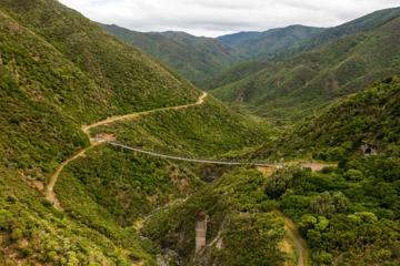 Looking into a valley in the Remutaka Range, where the Remutaka Cycle trail and swingbridge can be seen.