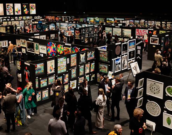 A crowded maze of walls covered in contemporary art pieces on display at the NZ Art Show.