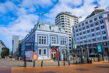 Exterior of the Wellington Museum, a blue building with a red door.