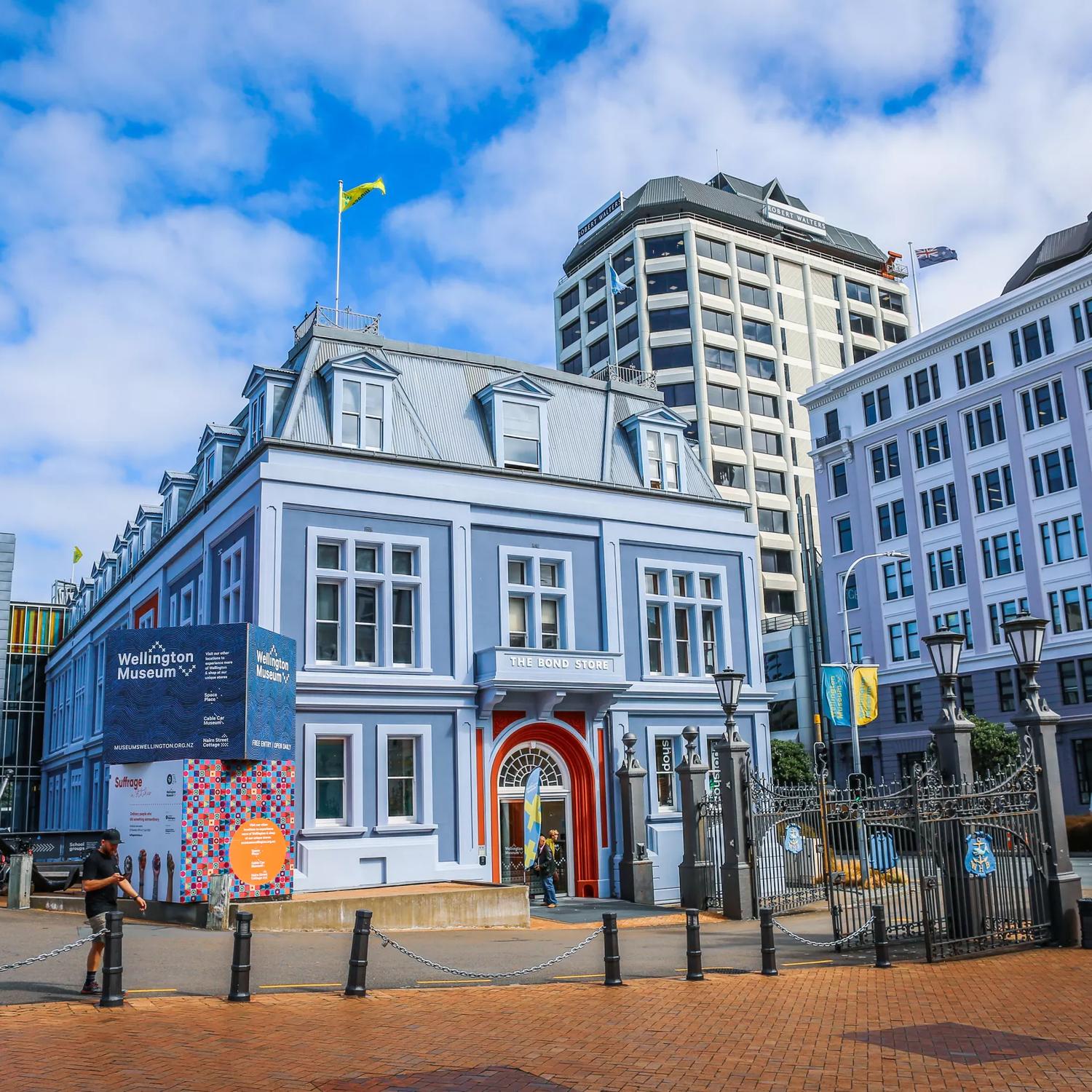 Exterior of the Wellington Museum, a blue building with a red door.