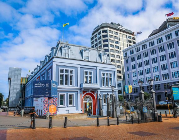 Exterior of the Wellington Museum, a blue building with a red door.