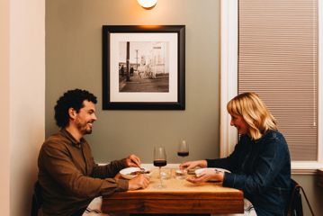 A couple enjoy food and wine at a restaurant.