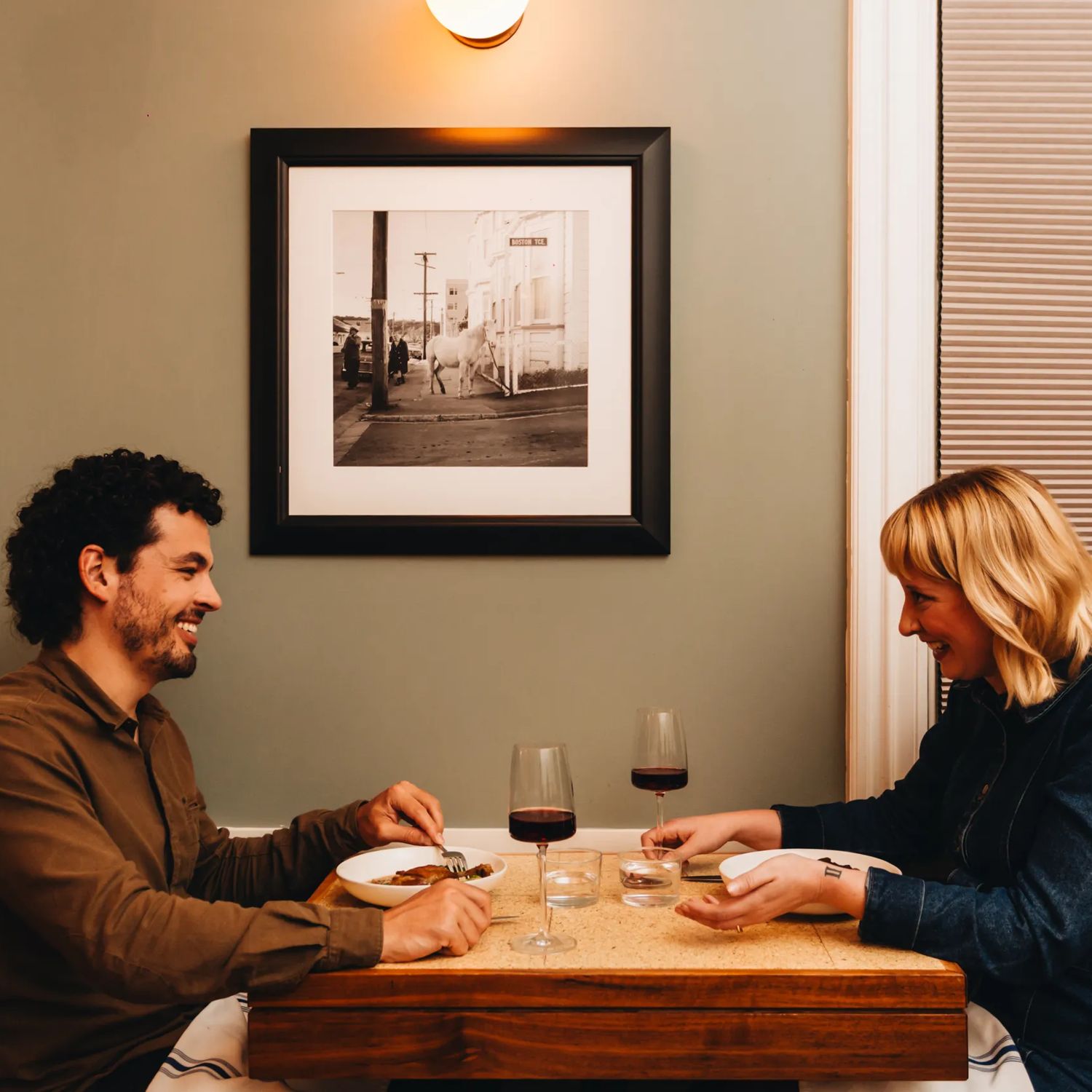 A couple enjoy food and wine at a restaurant.