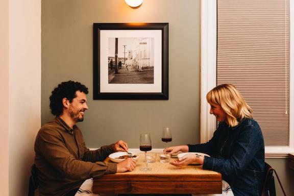 A couple enjoy food and wine at a restaurant.