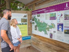 Two people look at a Map of East Harbour Regional Park.