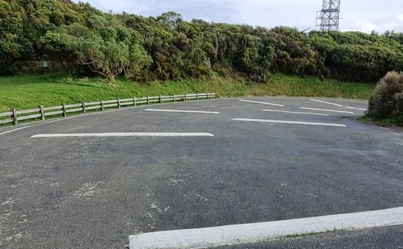 Concrete car park with white speed bumps.