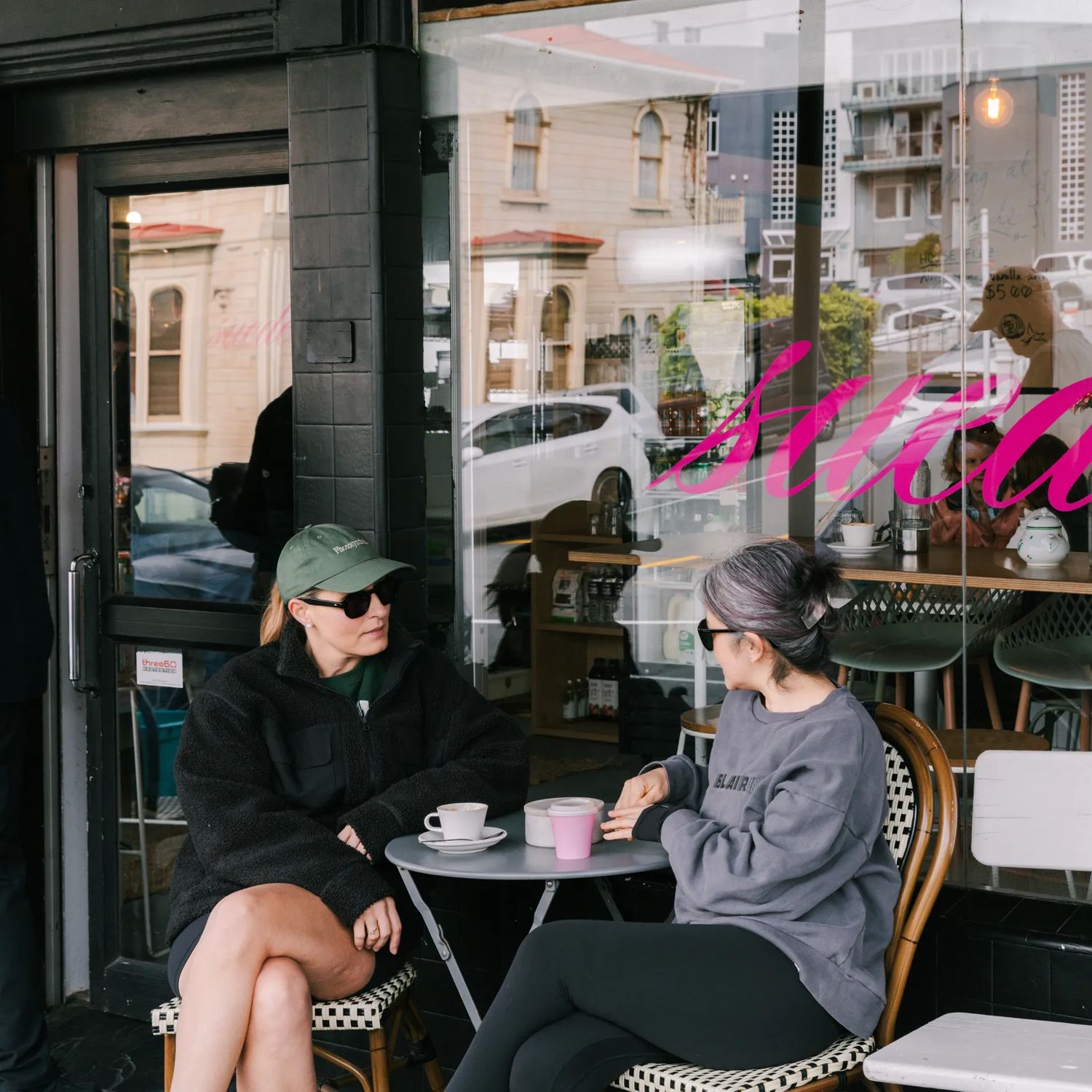 People enjoying coffee outside Suede Café’s street-front window.