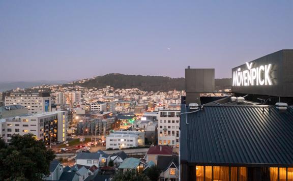 An aerial shot of the Mövenpick Hotel, overlooking Wellington city with lights glittering at dusk.