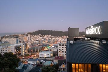 An aerial shot of the Mövenpick Hotel, overlooking Wellington city with lights glittering at dusk.