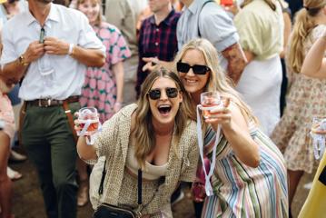 Two friends drinking rosé wine and posing for a picture.