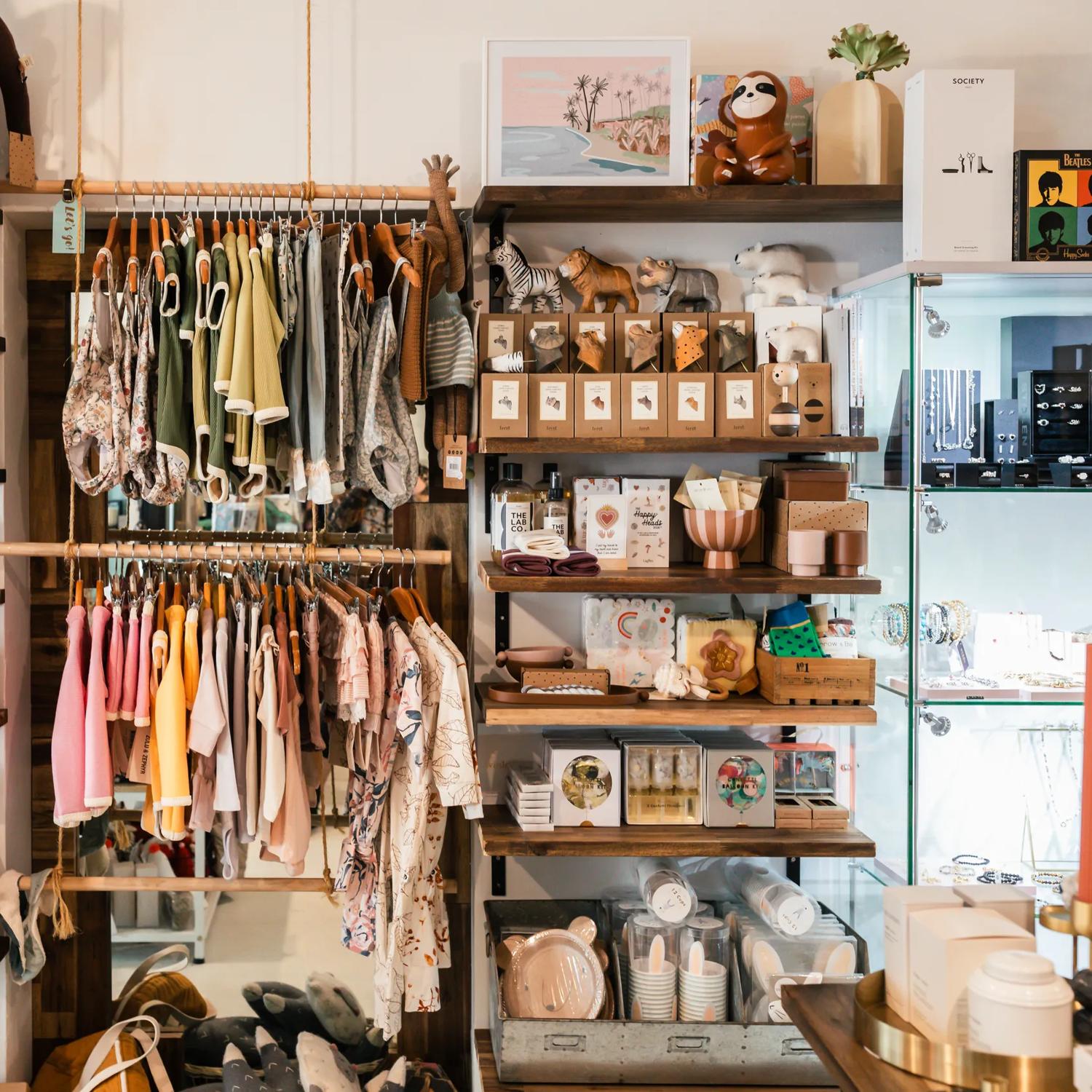 Inside Cre8iveworx boutique shop wooden shelves filled with children's books, toys and clothes for sale. 