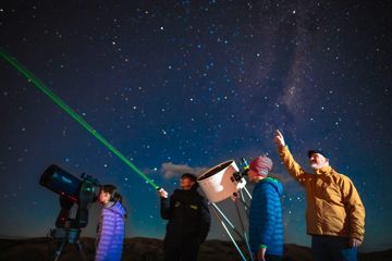 Four people stargazing under a clear sky at Star Safari in the Wairarapa Dark Sky reserve.