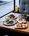 Various brunch dishes, a coffee and a mimosa on a table at Two Grey.