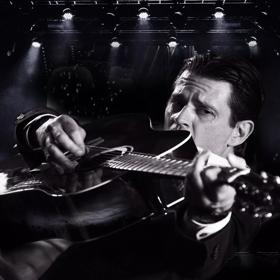 person holding guitar close to the camera, the image is black and white.