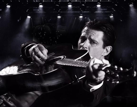 person holding guitar close to the camera, the image is black and white.