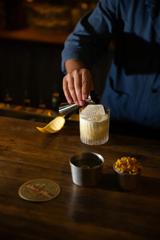 A person wearing a blue shirt makes a cocktail at Dee's Place, a bar in Te Reo, Wellington.