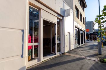 The storefront of a boutique clothing store. It's a white building with glass doors.
