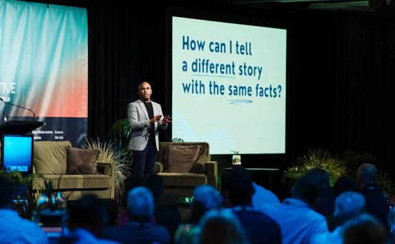 Jehan Casinader, keynote speaker at a business conference gives a presentation on wellbeing in the workplace.