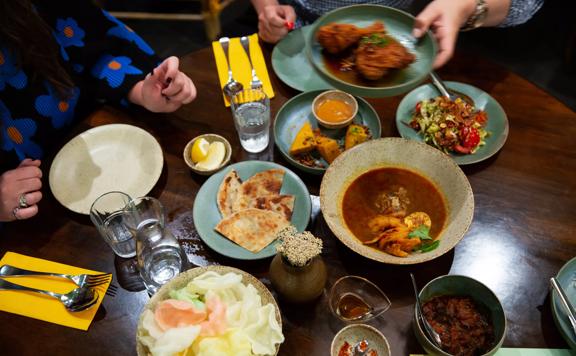 A table teeming with colourful dishes at Mabel's, a Burmese restaurant in Te Aro, Wellington. 