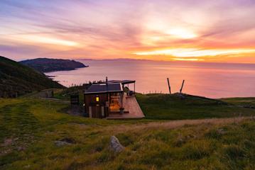 Tunapo Escape high on the hills of Paekākāriki at sunset, overlooking Pukerua bay.