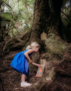 Young child plays with the fairy houses in Horoeka scenic reserve.