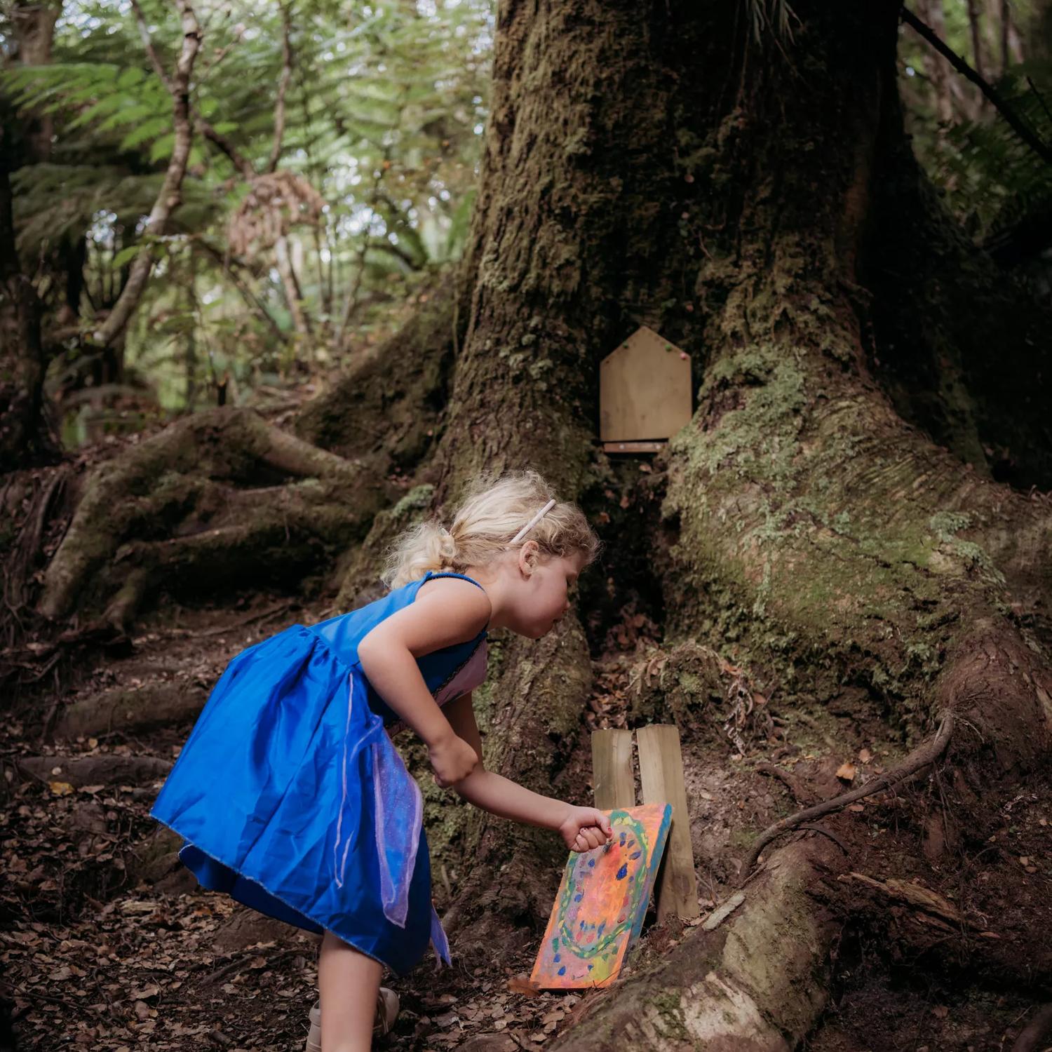 Young child plays with the fairy houses in Horoeka scenic reserve.