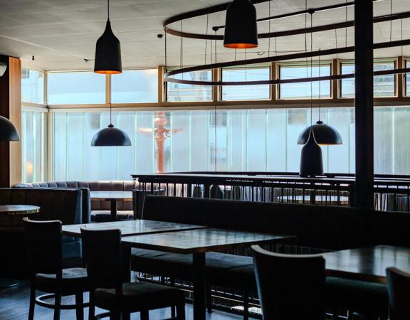 The interior of Alma House in Mount Cook. The brown hues of the leather booths and wood walls give an intimate and moody atmosphere.