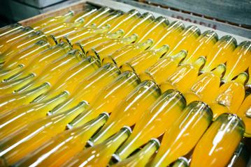 A shipping crate filled with bottles of yellow-orange liquid.