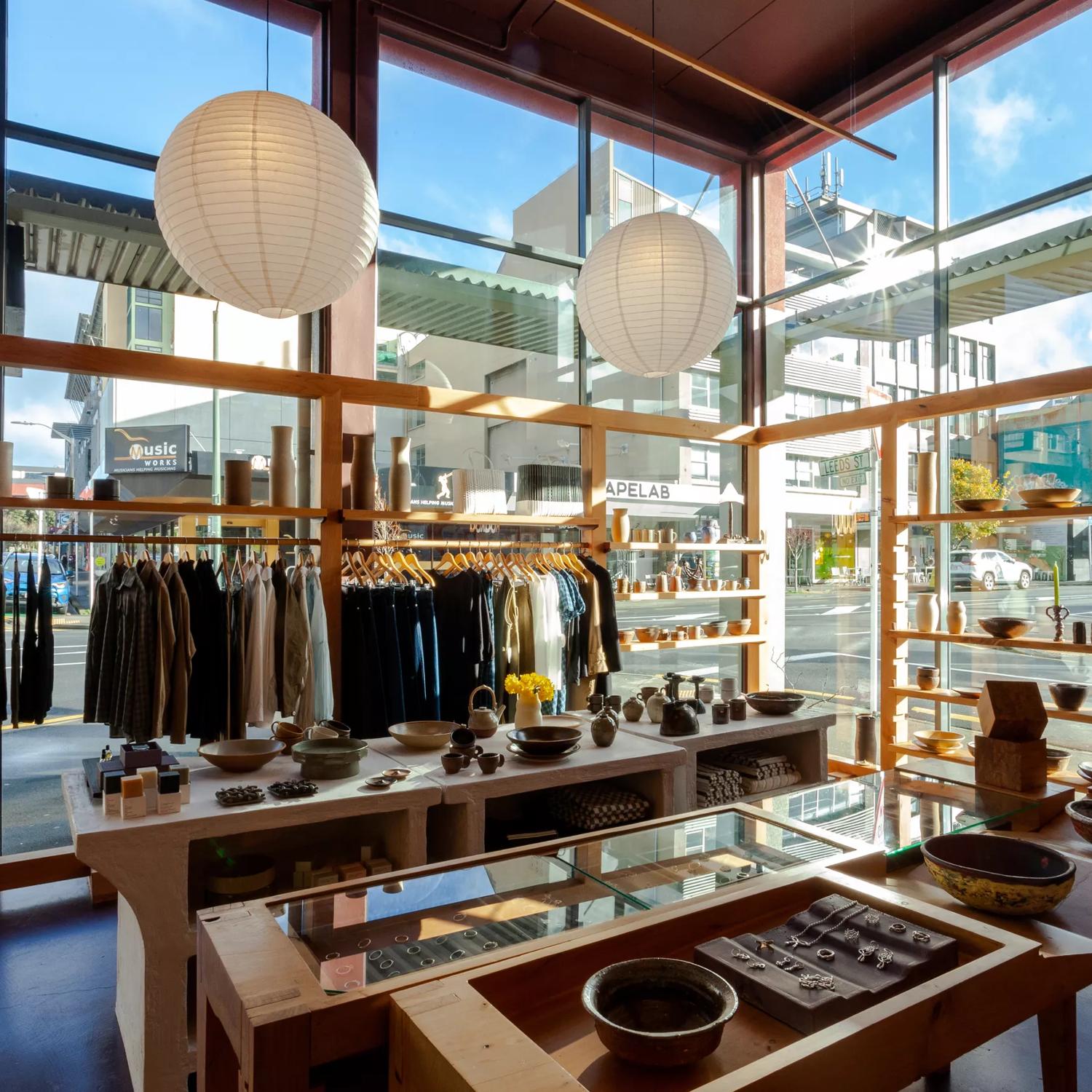 Inside Kaukau on ghuznee st, with large glass windows, clothes racks and wooden display tables.