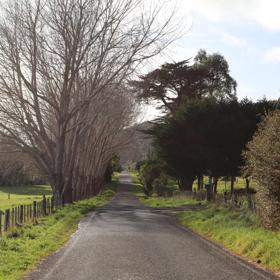 Mangaroa Valley Road screen location, a scenic rural setting with native forest, farmland, and a mountainous backdrop.