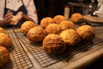 Freshly baked cheese scones arranged on a cooling rack.