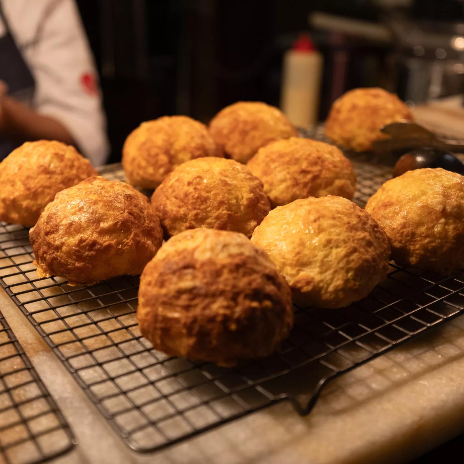 Freshly baked cheese scones arranged on a cooling rack. 