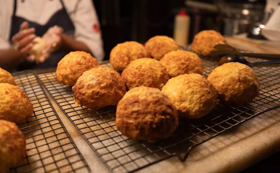 Freshly baked cheese scones arranged on a cooling rack.