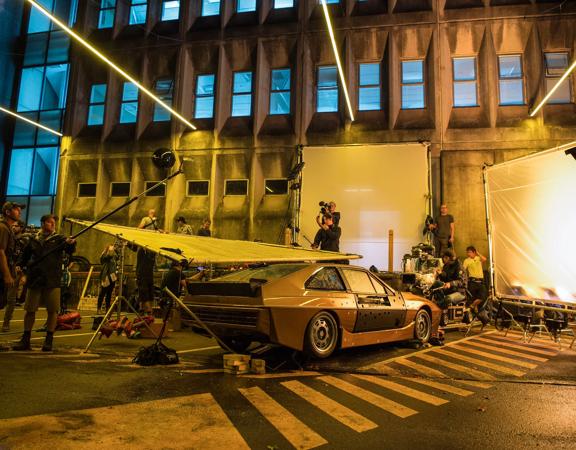 Retro car on set of 
Ghost in the Shell, dim moody lighting with film crew.