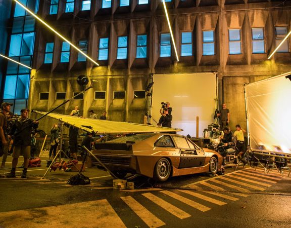 Retro car on set of 
Ghost in the Shell, dim moody lighting with film crew.