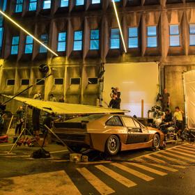 Retro car on set of 
Ghost in the Shell, dim moody lighting with film crew.
