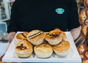 A tray of six savoury pies is held for display at Nada Bakery.