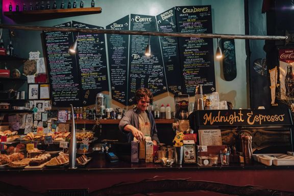 Front counter at Midnight Espresso with the menu displayed in colourful writing on large black chalkboards on the wall.