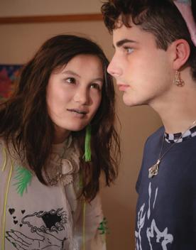 A still from the Wellington-based film, Little Apocalypse, with two people standing close to one another. One is staring at the other while the other is staring in the distance. 