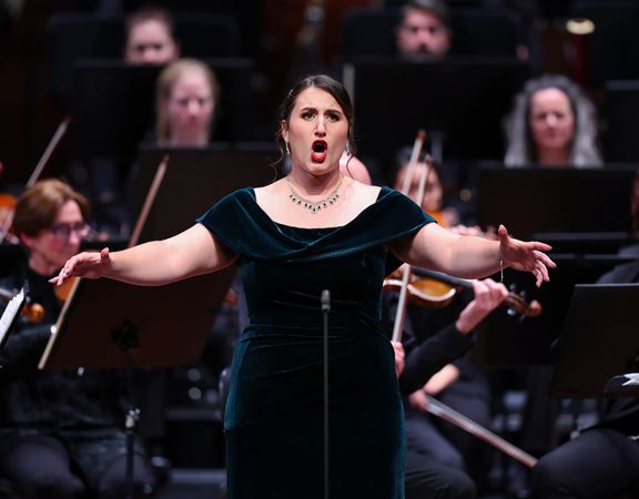 An opera singer performs with orchestral accompaniment.