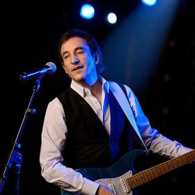 David Pomeranz plays guitar and sings on stage.