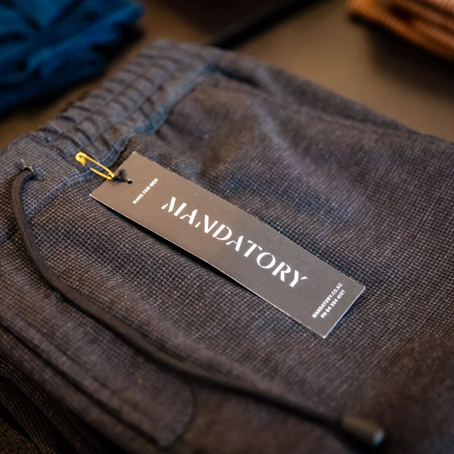 A close-up of pants folded on a tbale at Inside Mandatory, a menswear clothing store.