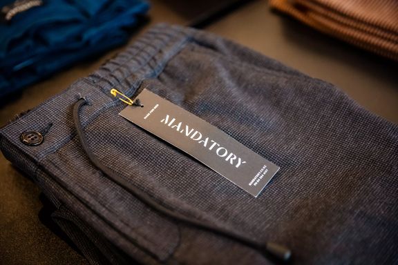 A close-up of pants folded on a tbale at Inside Mandatory, a menswear clothing store.