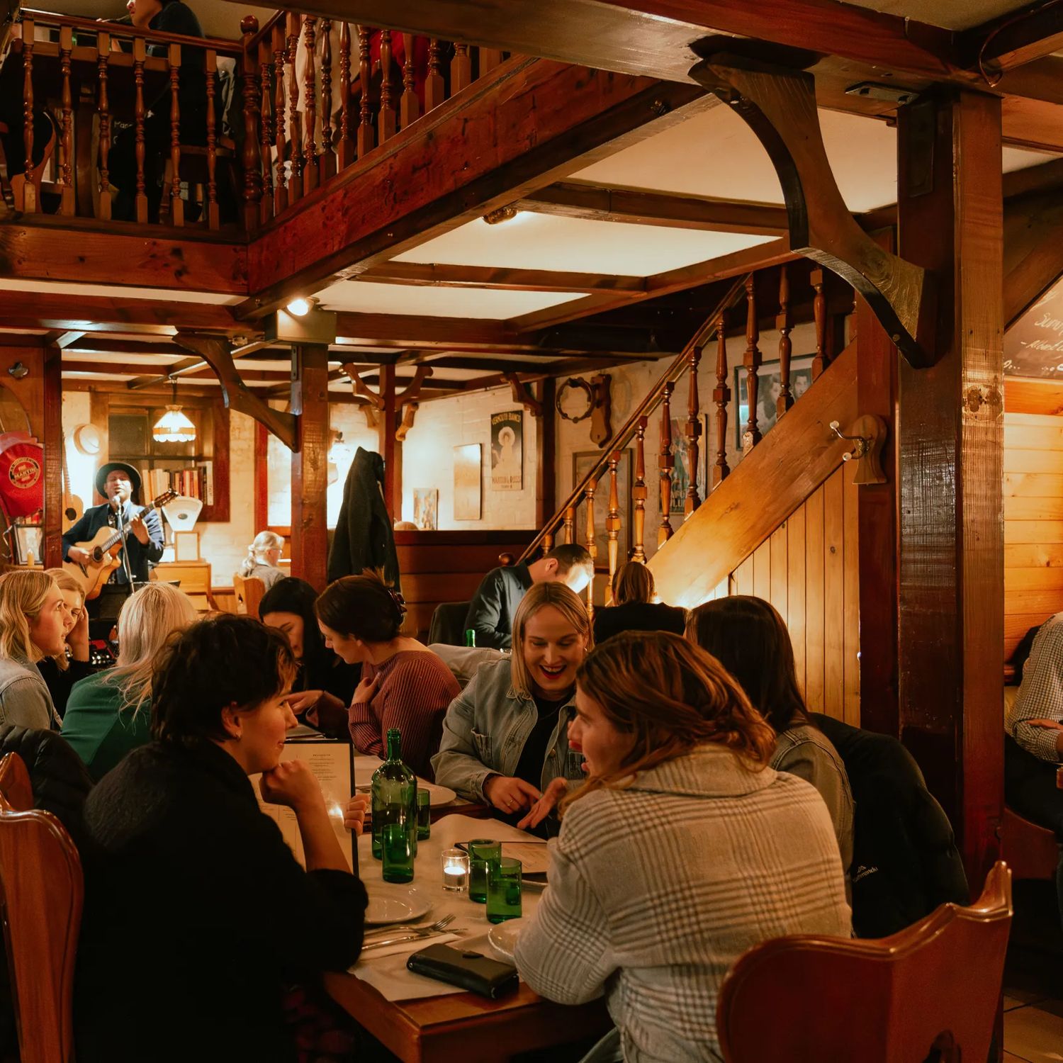 The rustic interior of Cicio Cacio, an Italian restaurant in Newtown, Wellington, is full of people enjoying food and drinks.