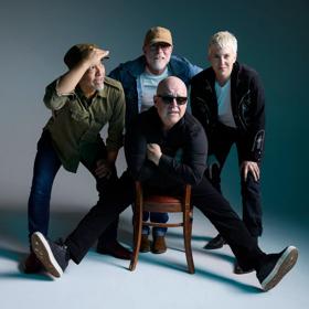 The four members of the Pixies pose in front of a grey background.