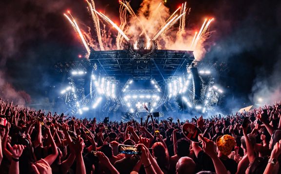 Packed crowd at ULTRA music festival showing the stage with bright lights and fireworks