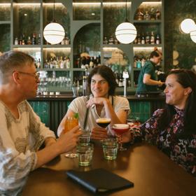 Three friends enjoy cocktails at Hummingbird Restaurant & Lounge.