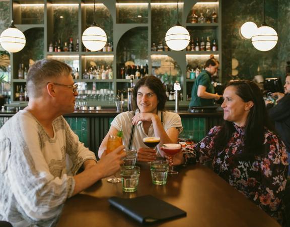 Three friends enjoy cocktails at Hummingbird Restaurant & Lounge.